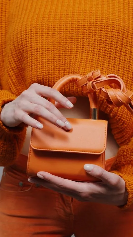 An orange bag clip with the hook “Everyone asks about this bag”.